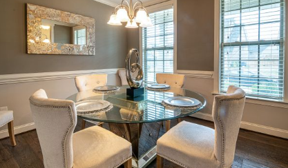 Elegant dining room with round glass table and upholstered chairs