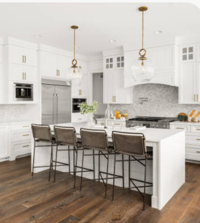 White kitchen with large island, gold pendant lighting, and bar seating